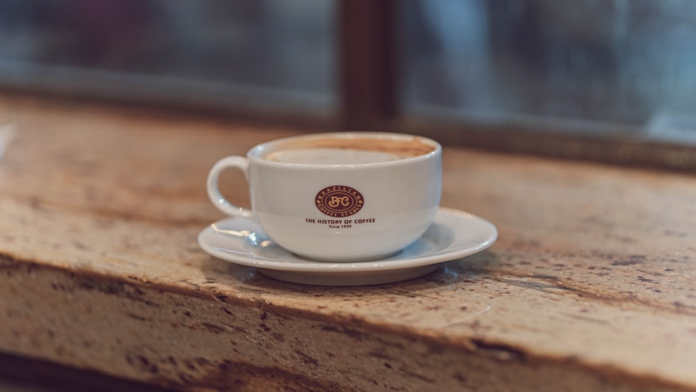 a cup of coffee sitting on top of a wooden counter