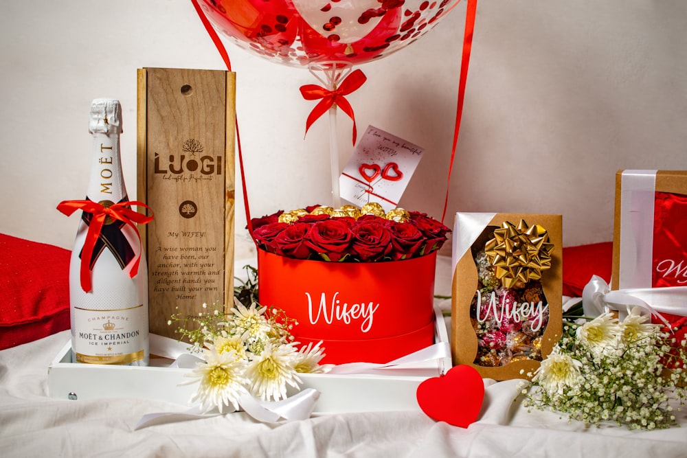 a table topped with a red bucket filled with flowers