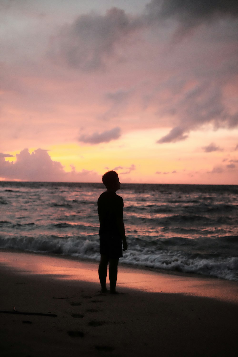 Eine Person, die an einem Strand am Meer steht