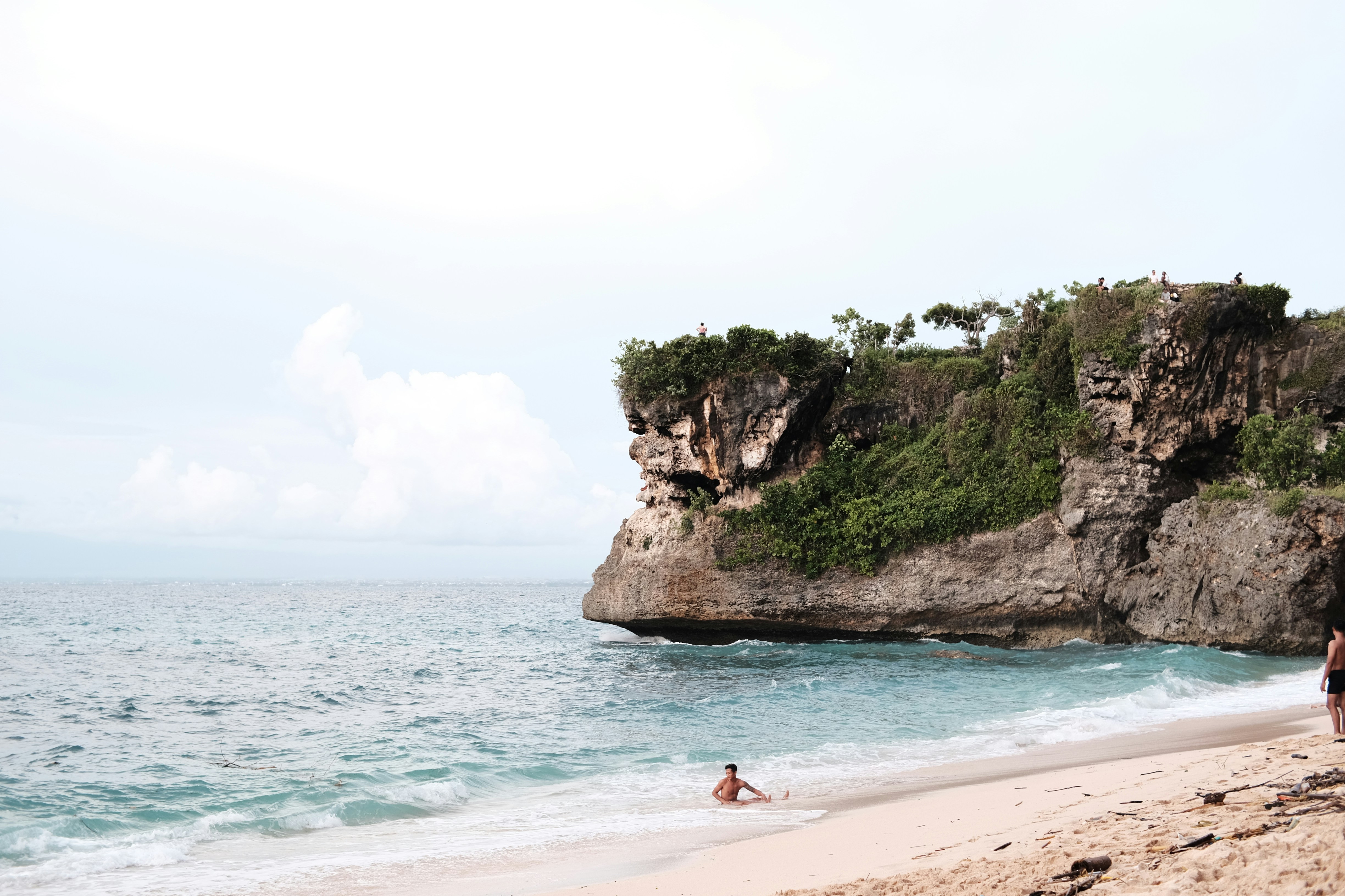 a couple of people standing on top of a sandy beach, 
