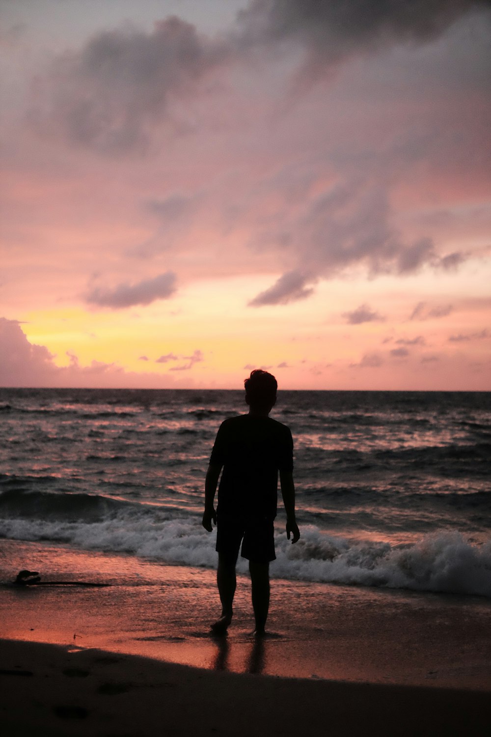 Ein Mann steht auf einem Strand am Meer