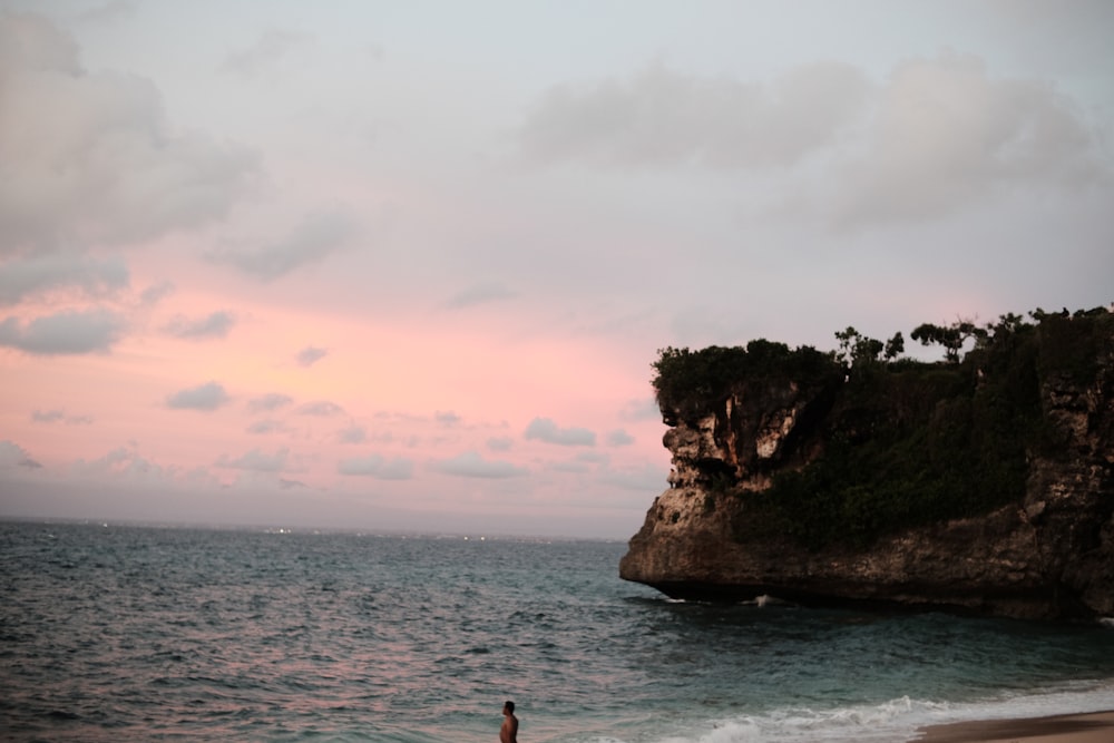 a person standing on a beach next to the ocean