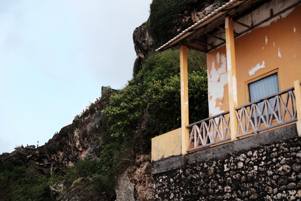 a building with a balcony next to a cliff