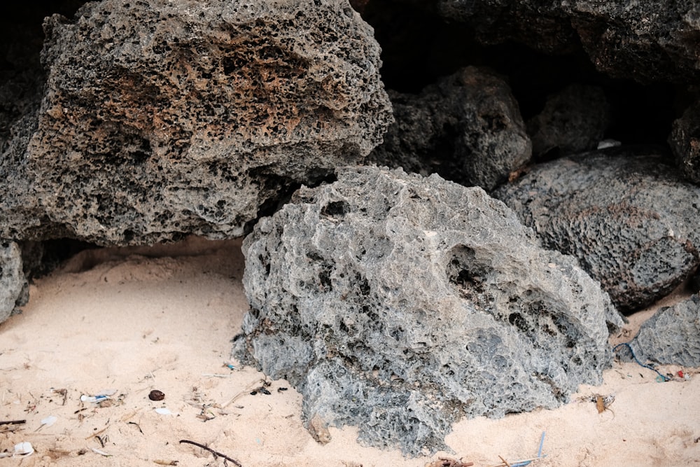 a pile of rocks sitting on top of a sandy beach