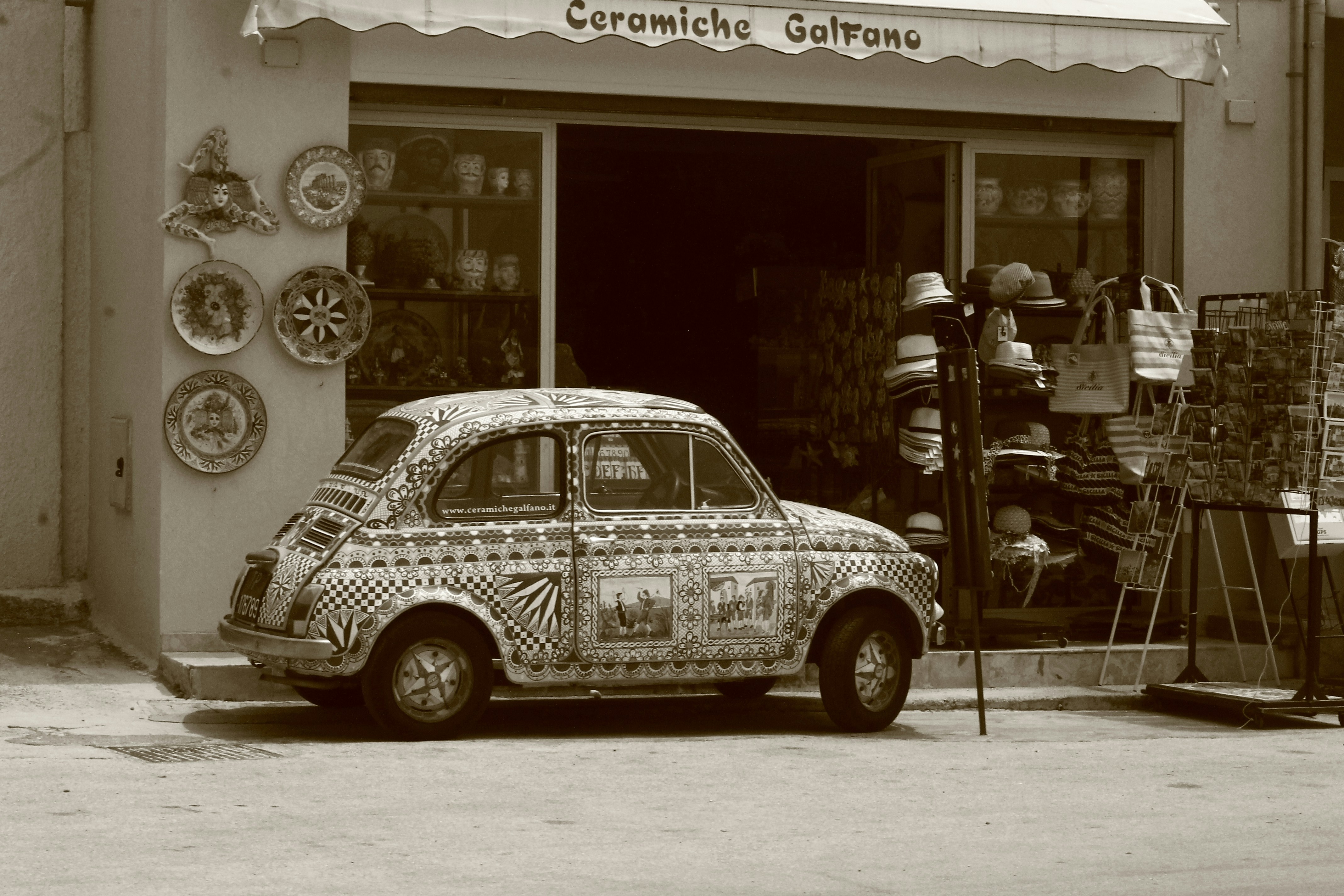 A decorative Fiat 500 resting outside of a souvenir store in the historic coastal town of Selinunte, on the Italian island of Sicily.