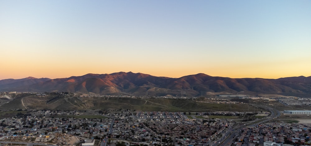 an aerial view of a city with mountains in the background