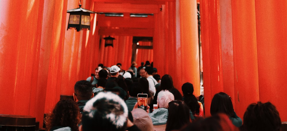 a group of people standing in front of a red building