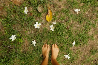 a person standing in the grass with their feet up