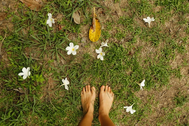a person standing in the grass with their feet up
