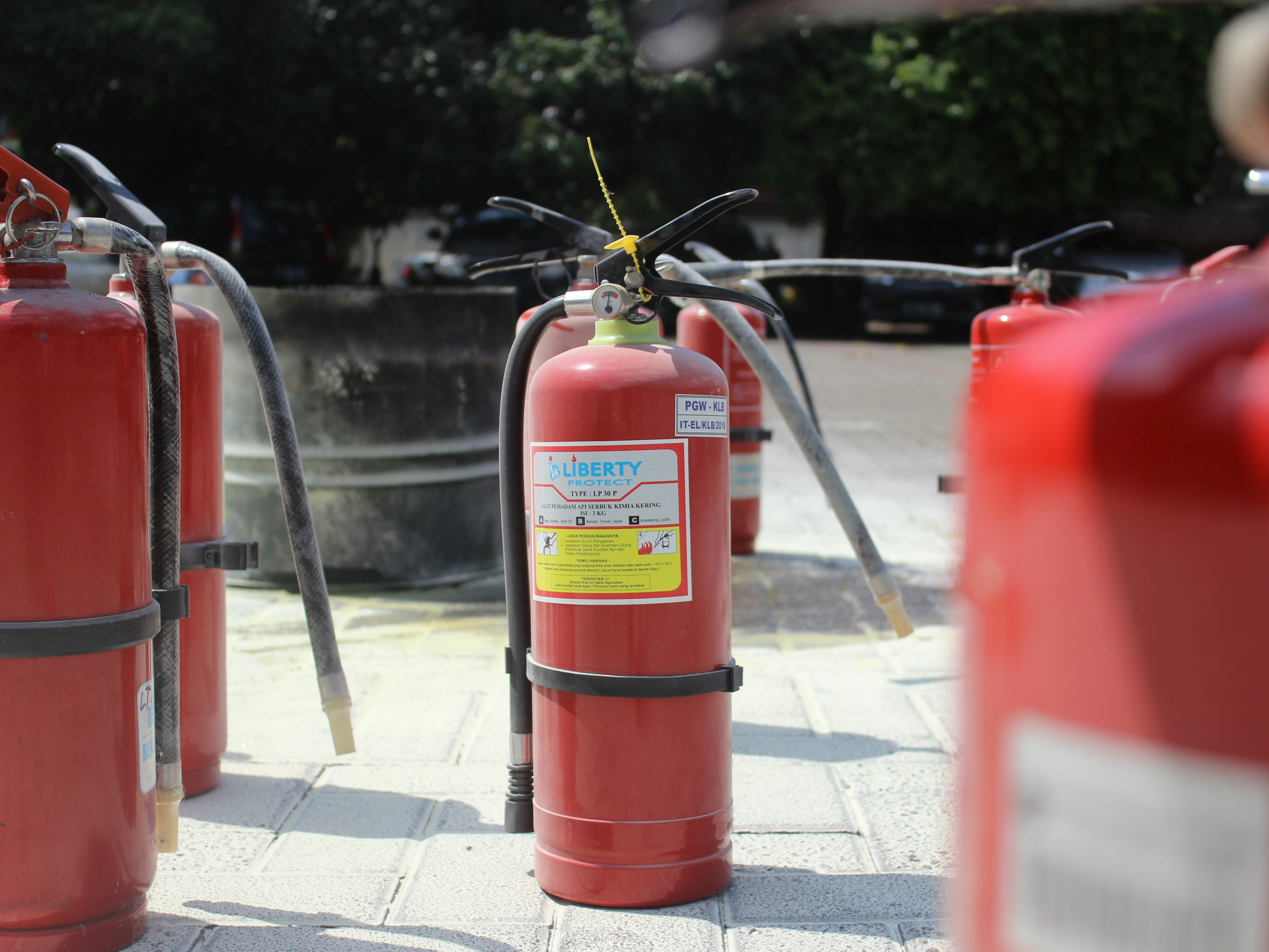 a group of red fire extinguishers sitting on a sidewalk