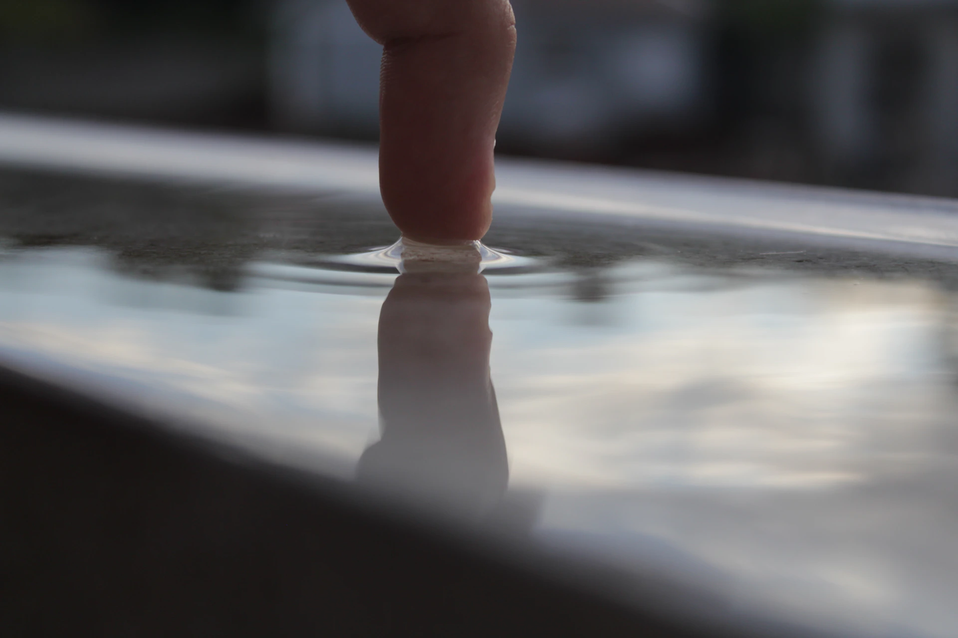 A series of circular, translucent ripples radiating from fingertips clicking on a minimalist interface with warm background lighting.