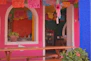 a pink and blue building with a wooden bench in front of it