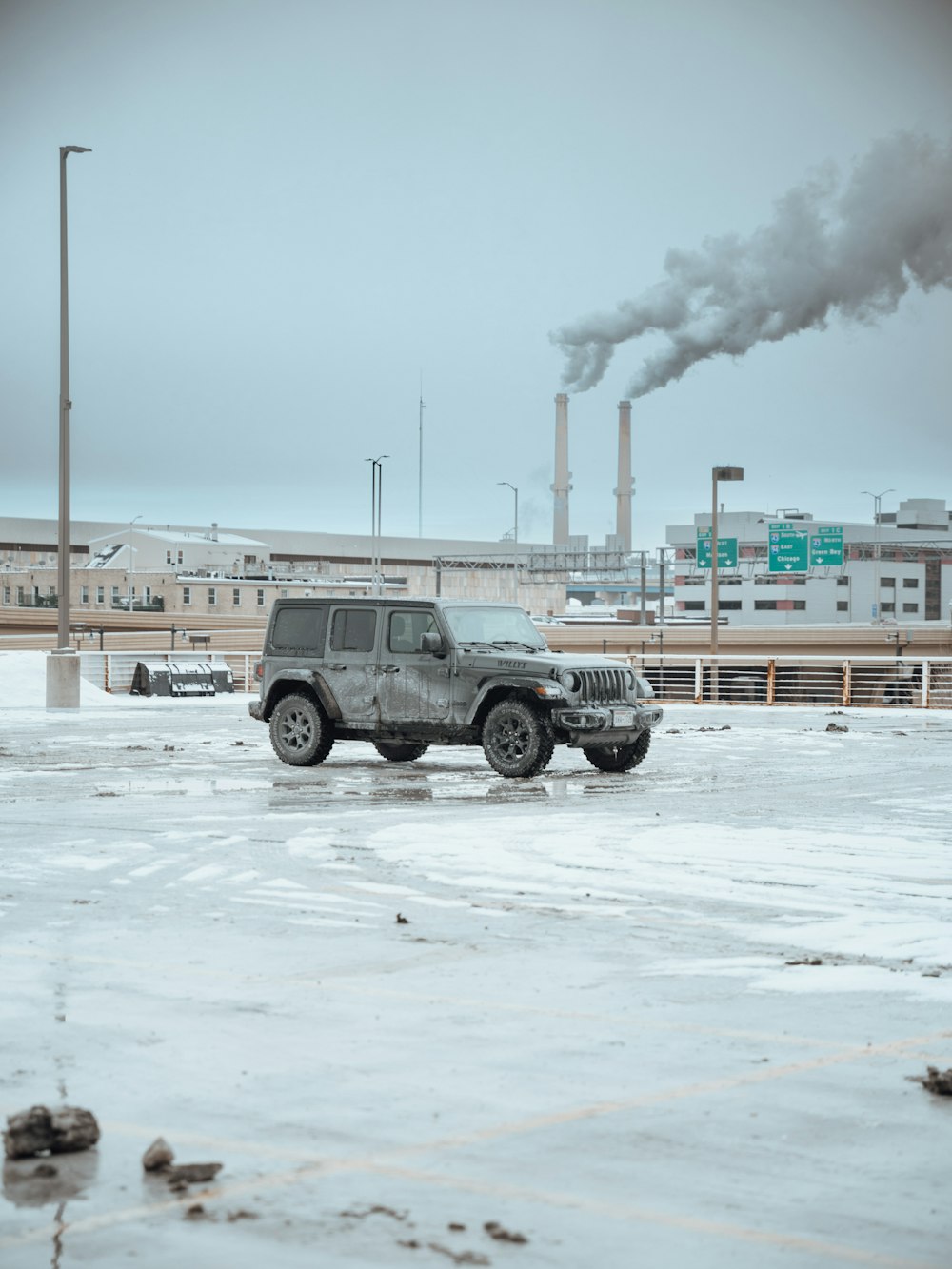 a gray jeep is parked in a parking lot