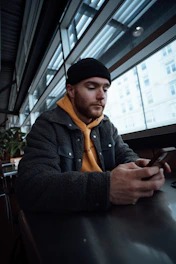a man sitting at a table looking at his cell phone