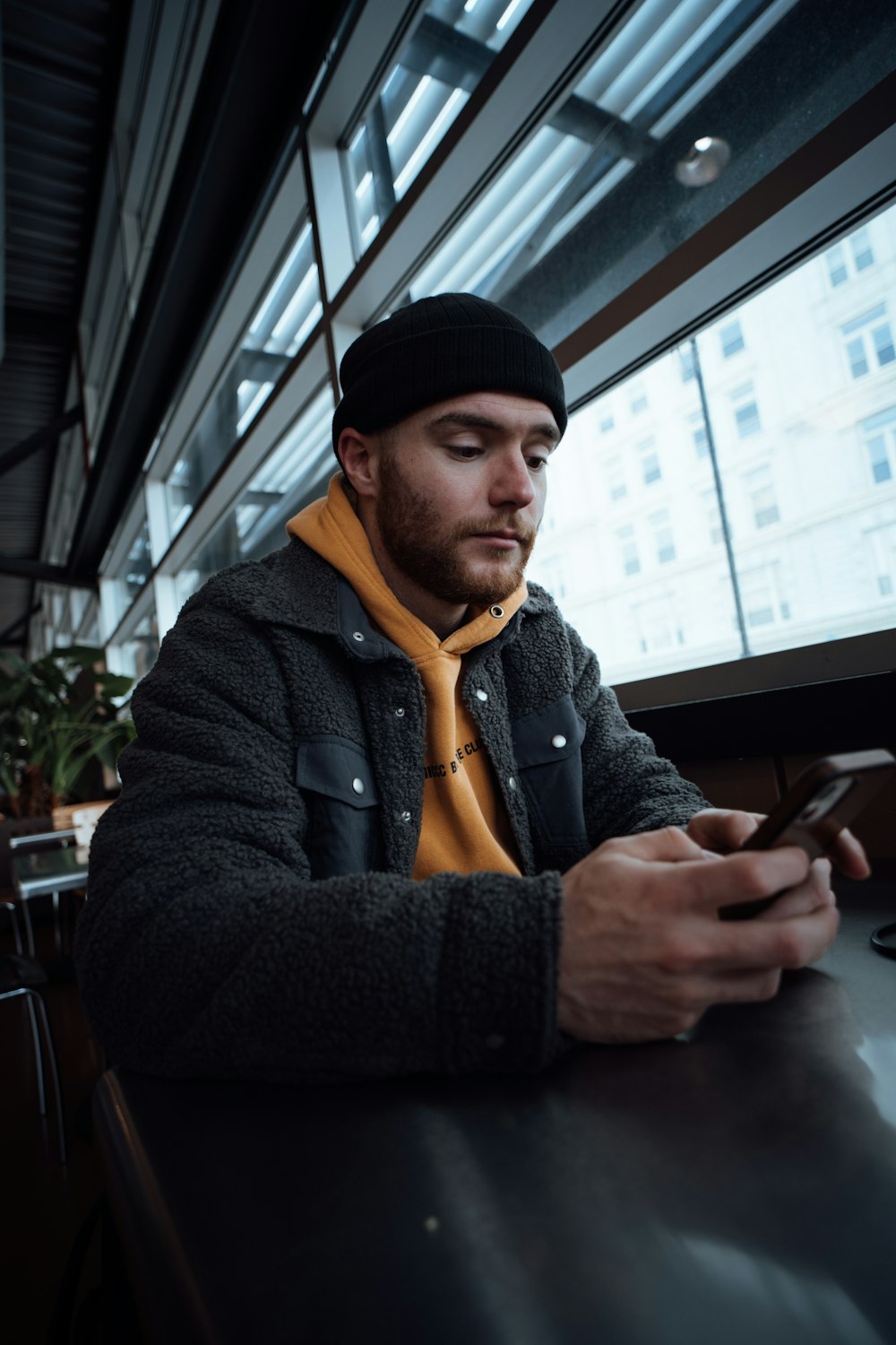 a man sitting at a table looking at his cell phone