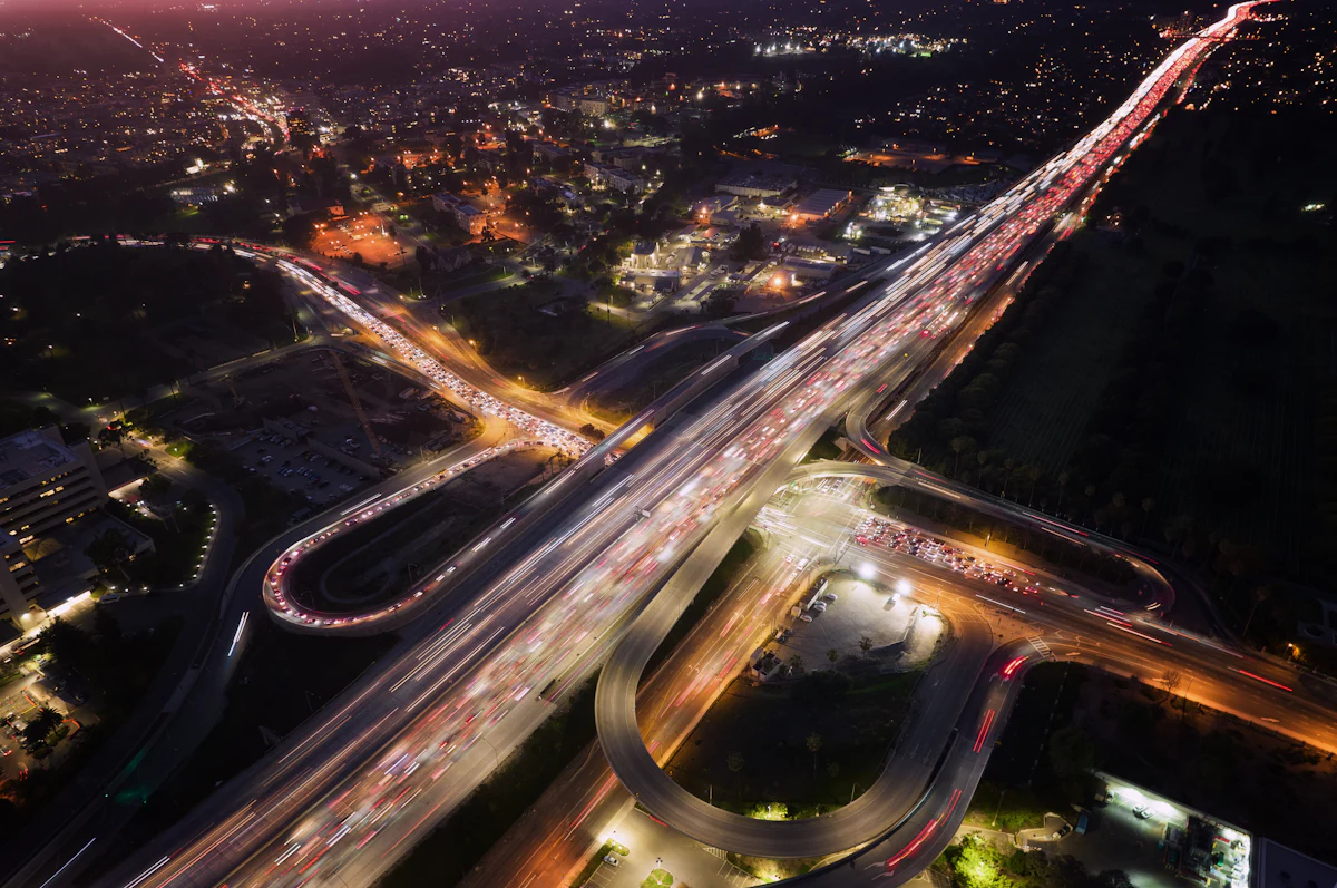 Night aerial view of a freeway interchange with traffic light trails