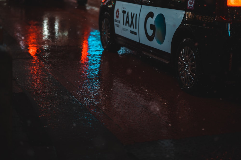 a taxi cab is parked on a rainy street