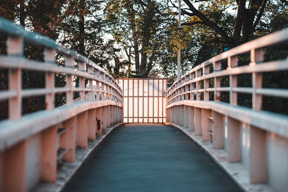 a long bridge with a gate and trees in the background