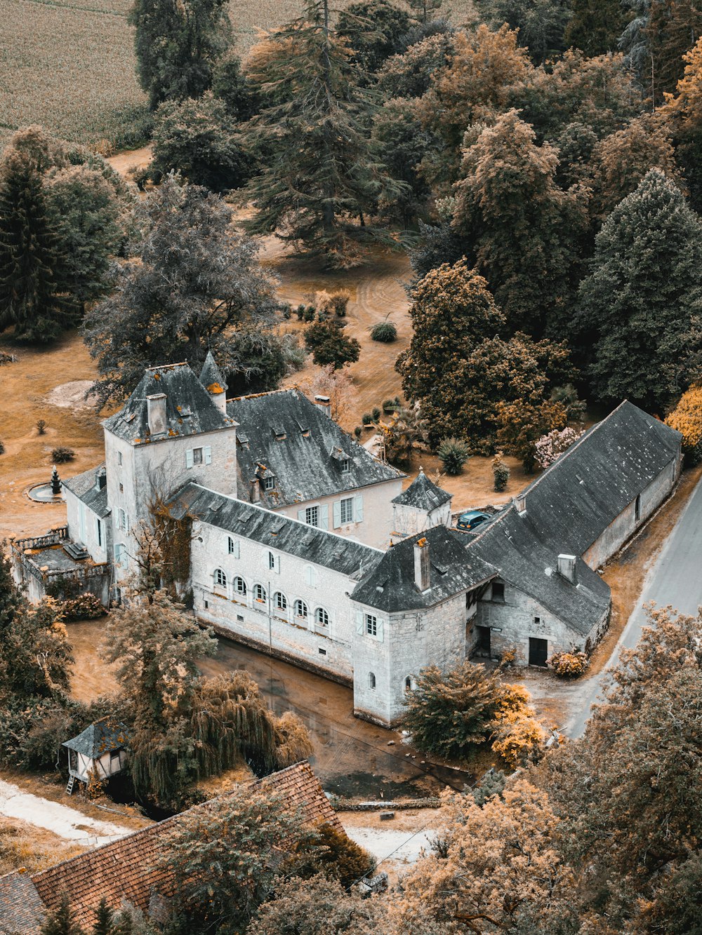 an aerial view of a large house surrounded by trees