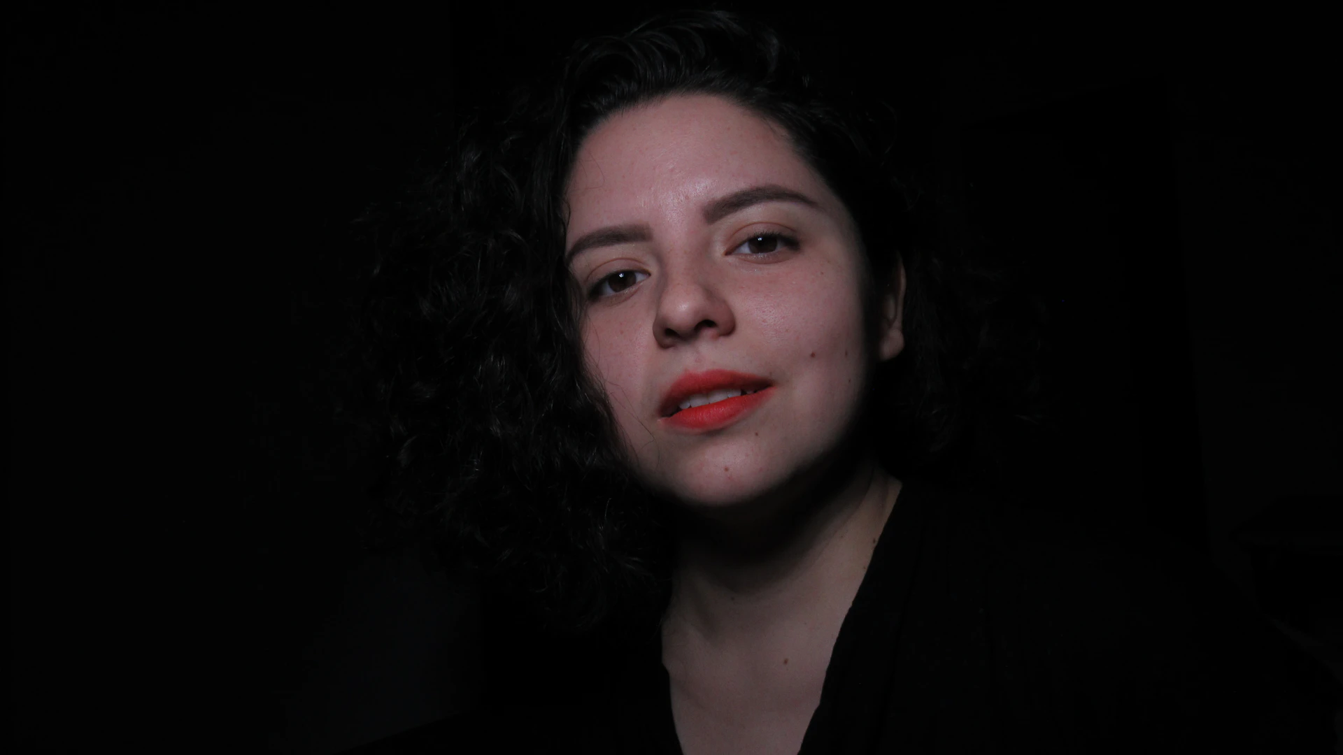 a woman with curly hair and a black shirt