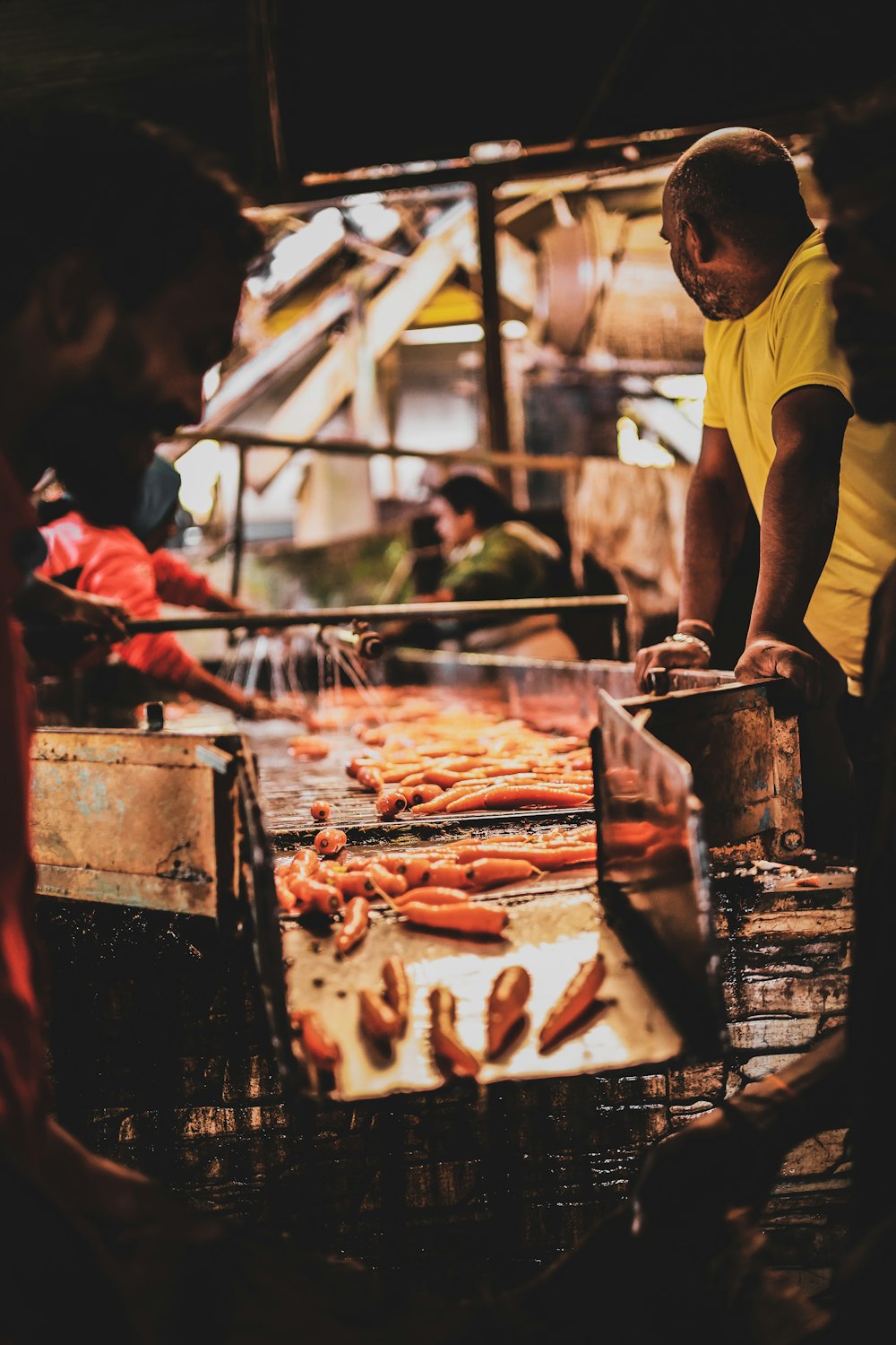 a man cooking hot dogs on a grill