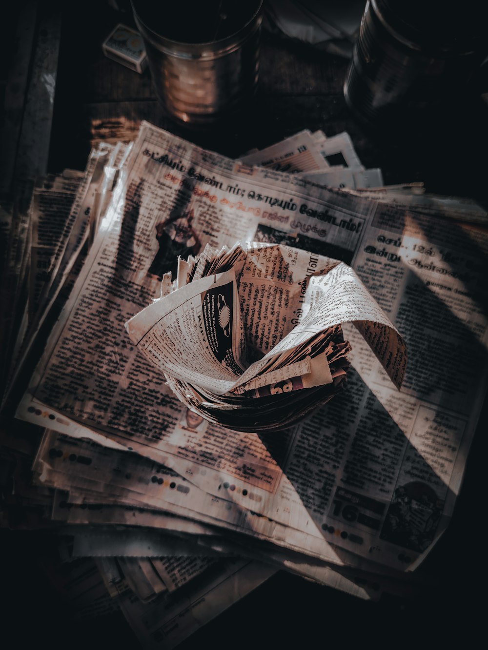 a pile of newspapers sitting on top of a table