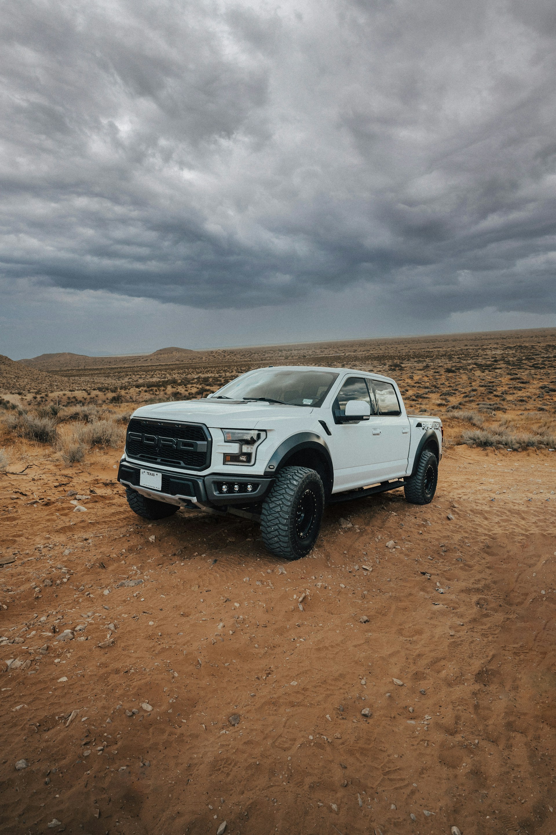 a white truck parked on a dirt road