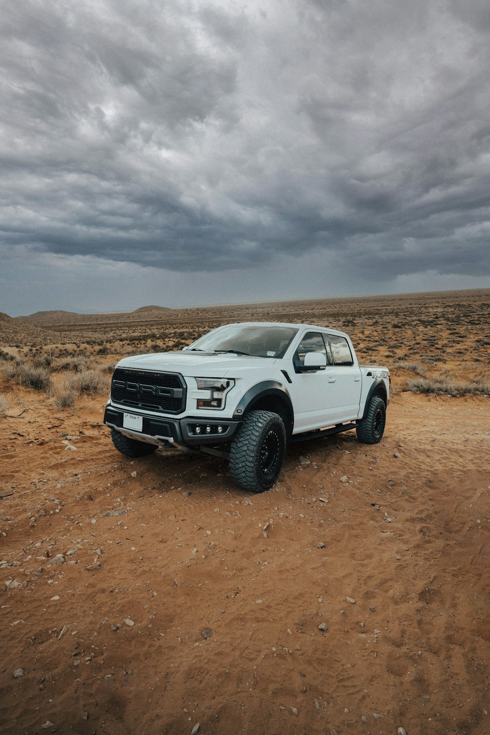 a white truck parked on a dirt road