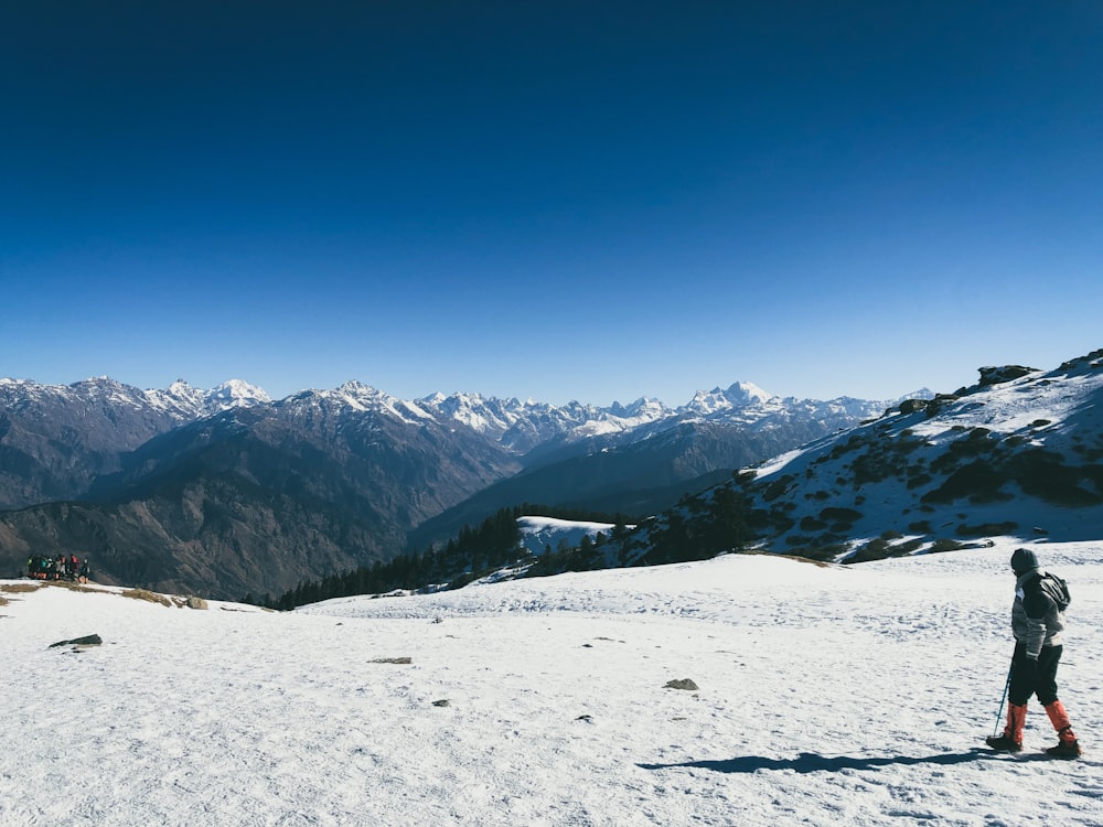 a man standing on top of a snow covered slope