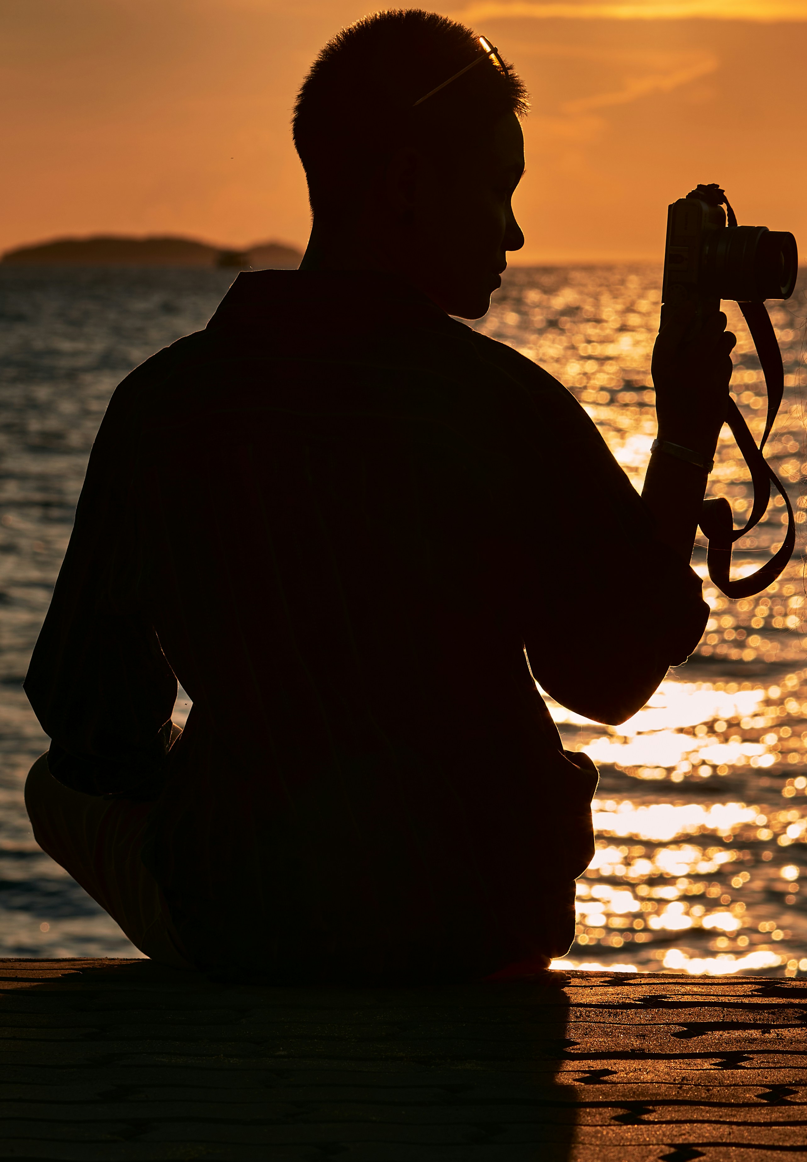 a man sitting on a dock holding a camera