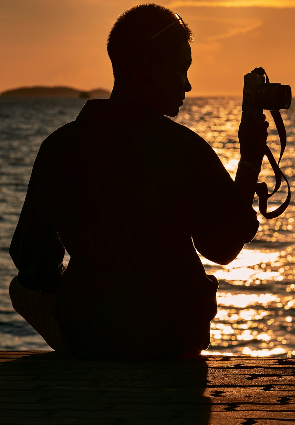 a man sitting on a dock holding a camera