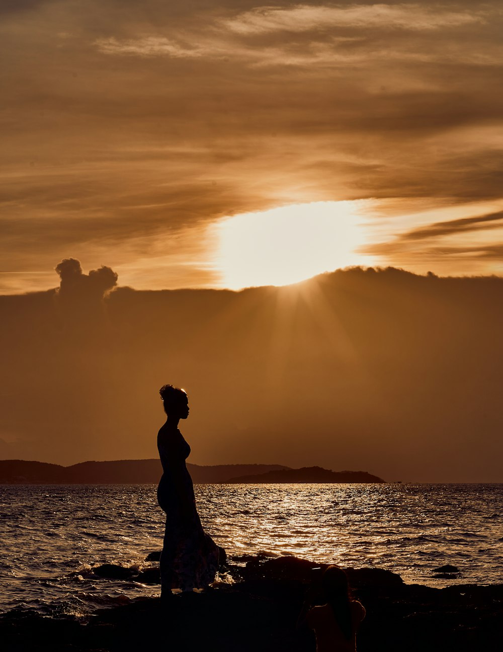 Une femme debout sur une plage rocheuse au bord de l’océan