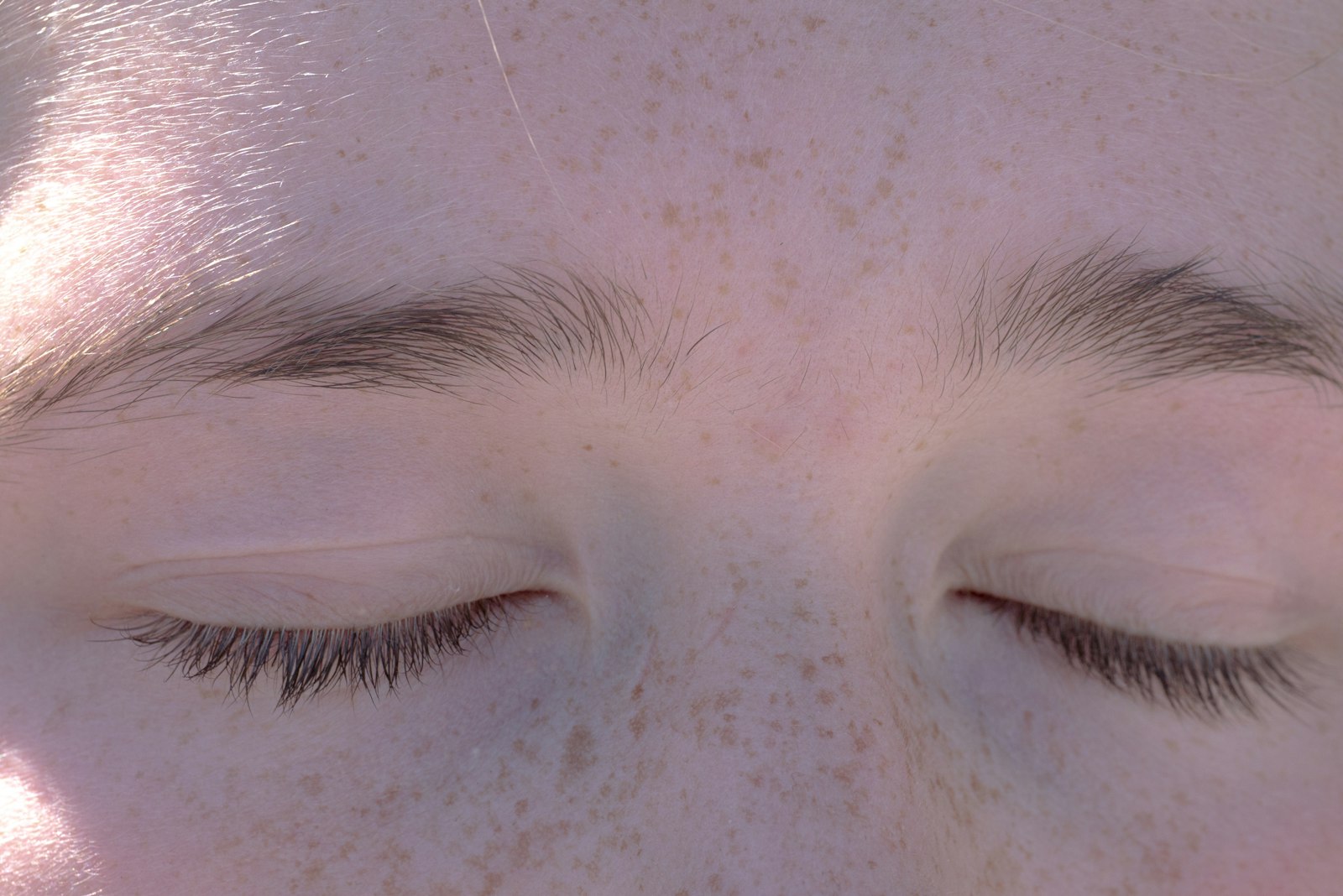 A soft, abstracted close-up of a person's closed eyes