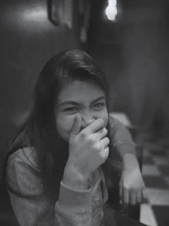 a young girl covers her face with her hands