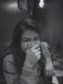 a young girl covers her face with her hands