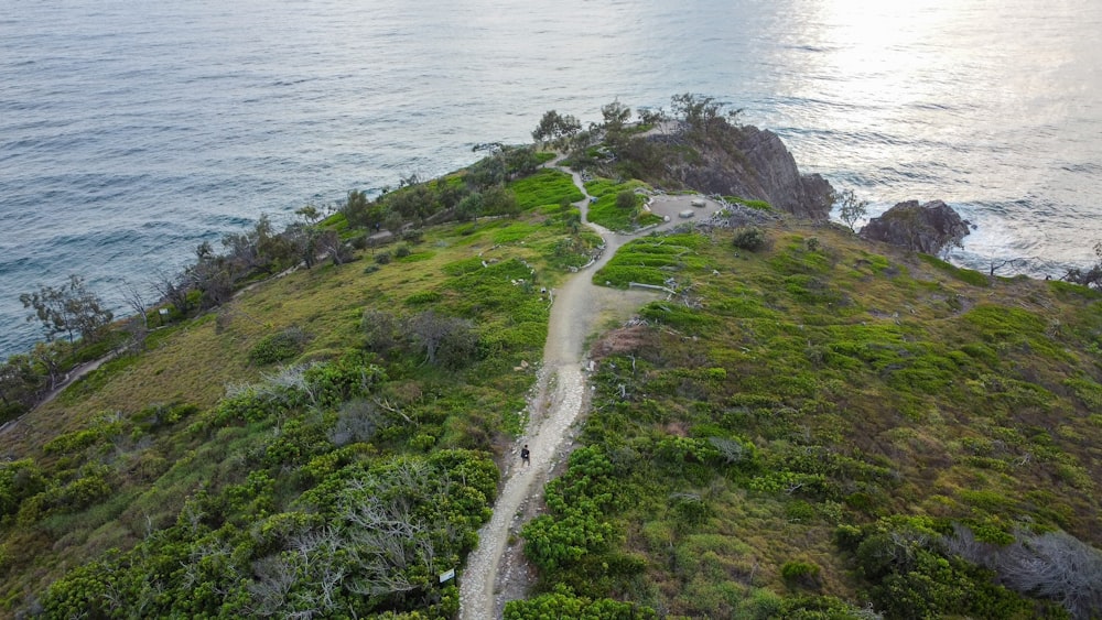 an aerial view of a path leading to the ocean