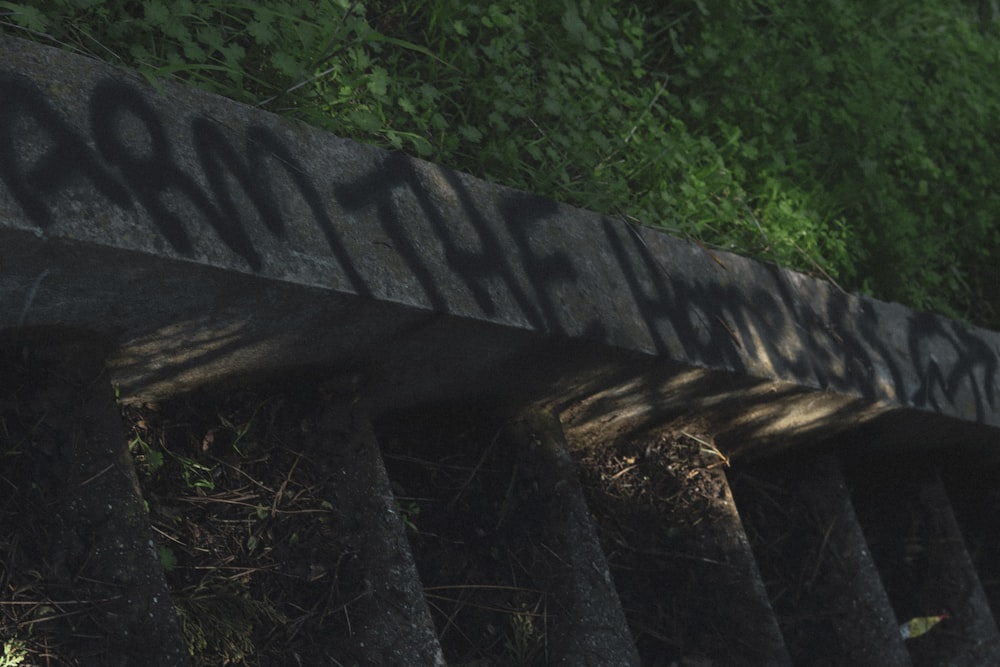 a wooden bench with graffiti on the side of it