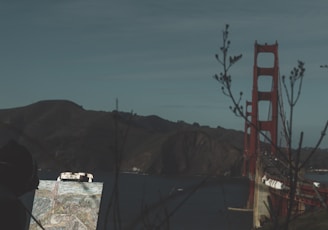 a person looking at a map in front of the golden gate bridge