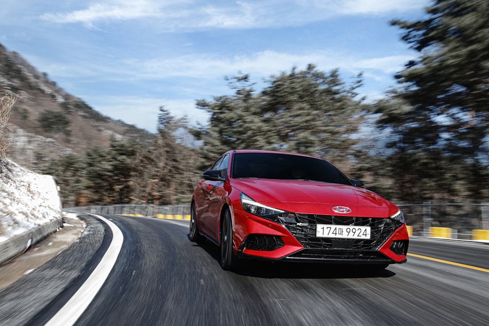 a red sports car driving down a road