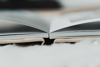 an open book sitting on top of a fluffy white blanket