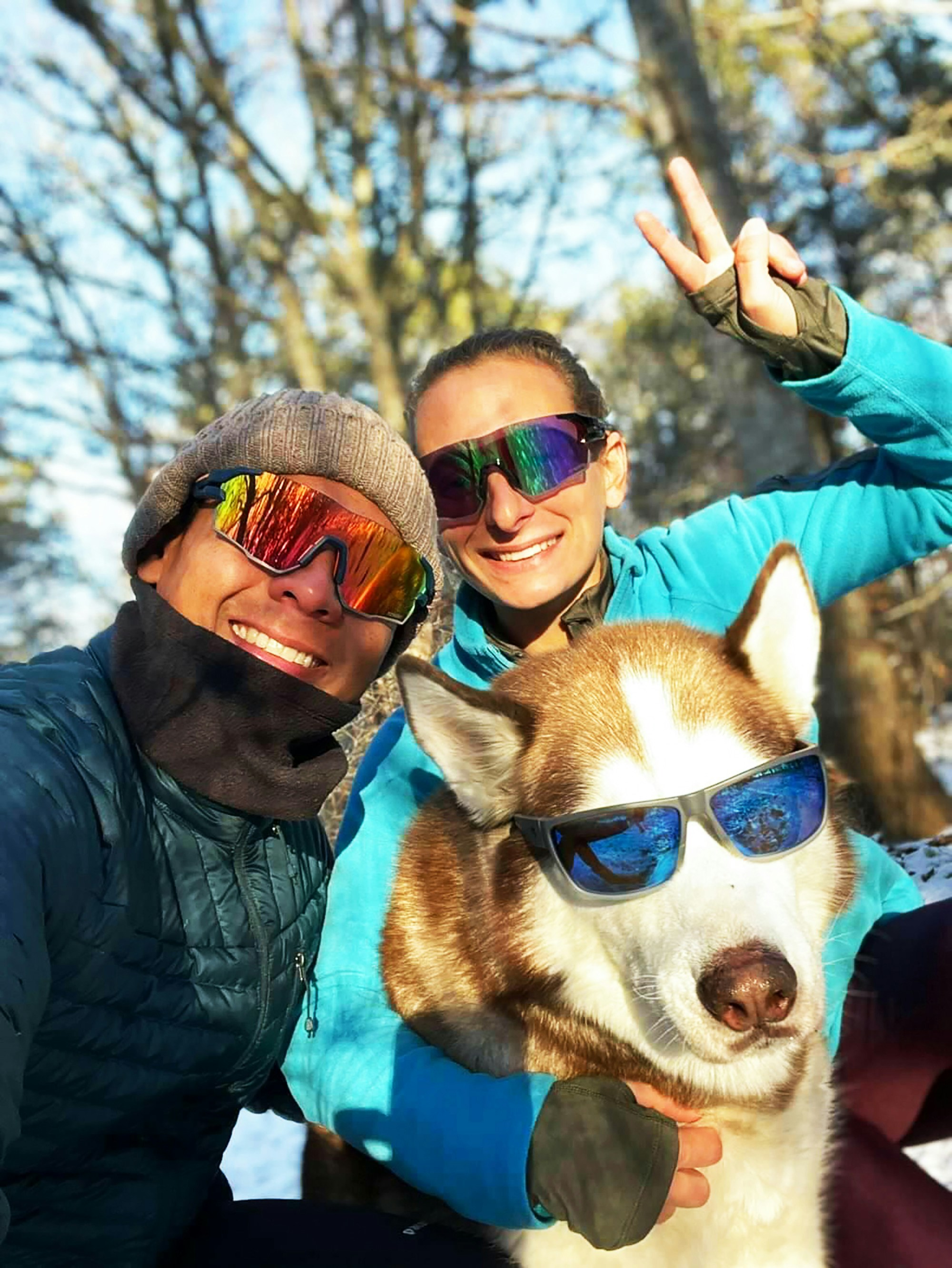ein paar Leute, die für ein Foto mit einem Hund posieren