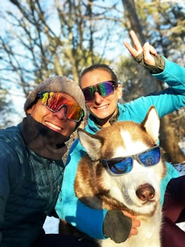 a couple of people that are posing for a picture with a dog