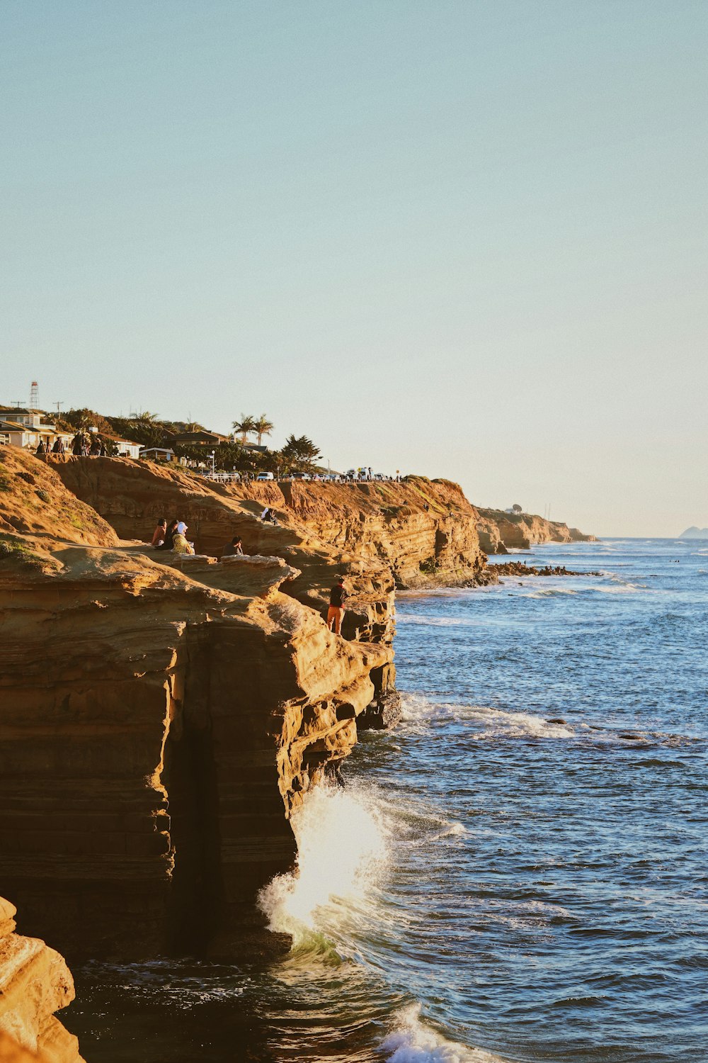 a rocky cliff with a body of water in the foreground