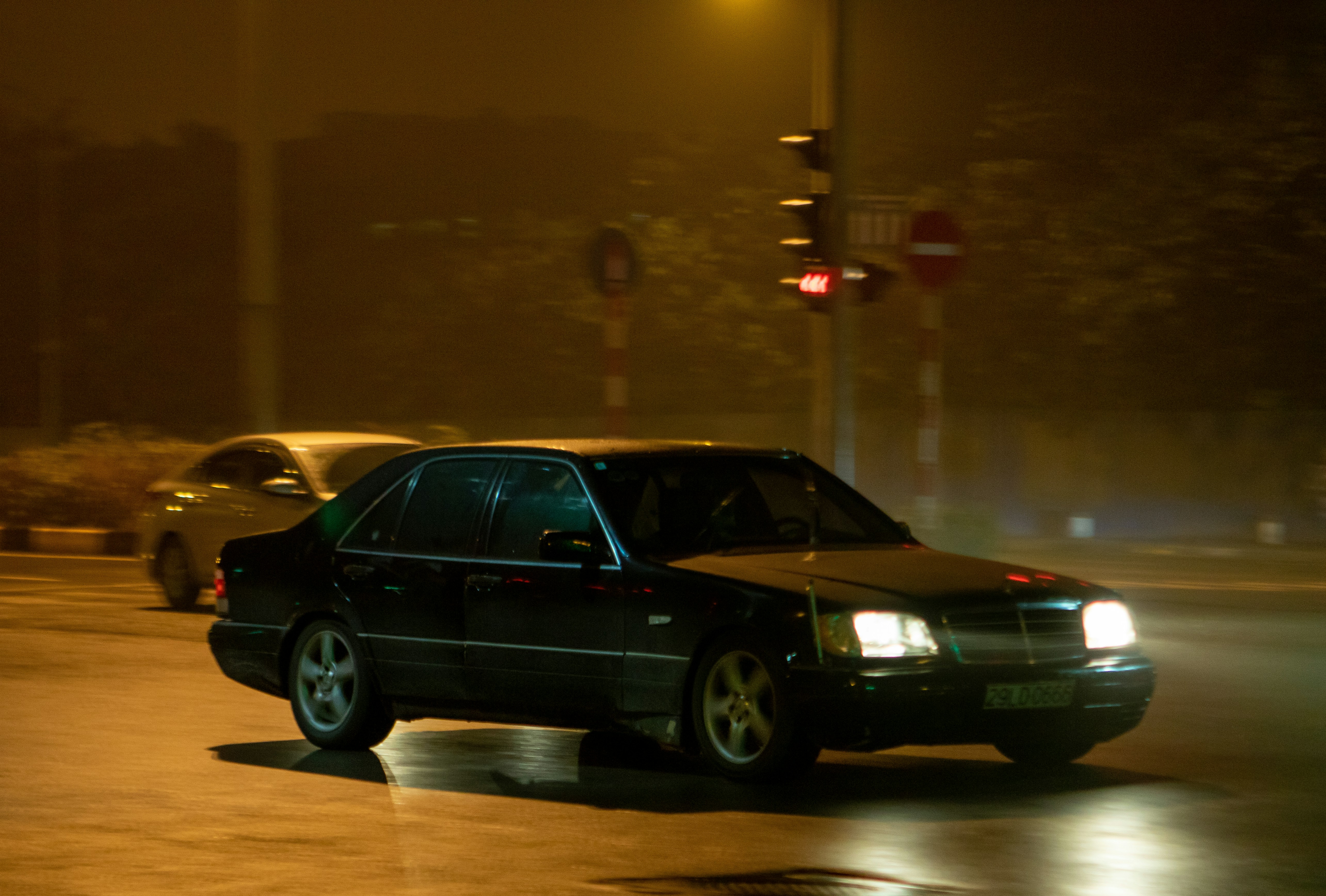 A black car driving down a street at night photo – Free Vehicle Image ...