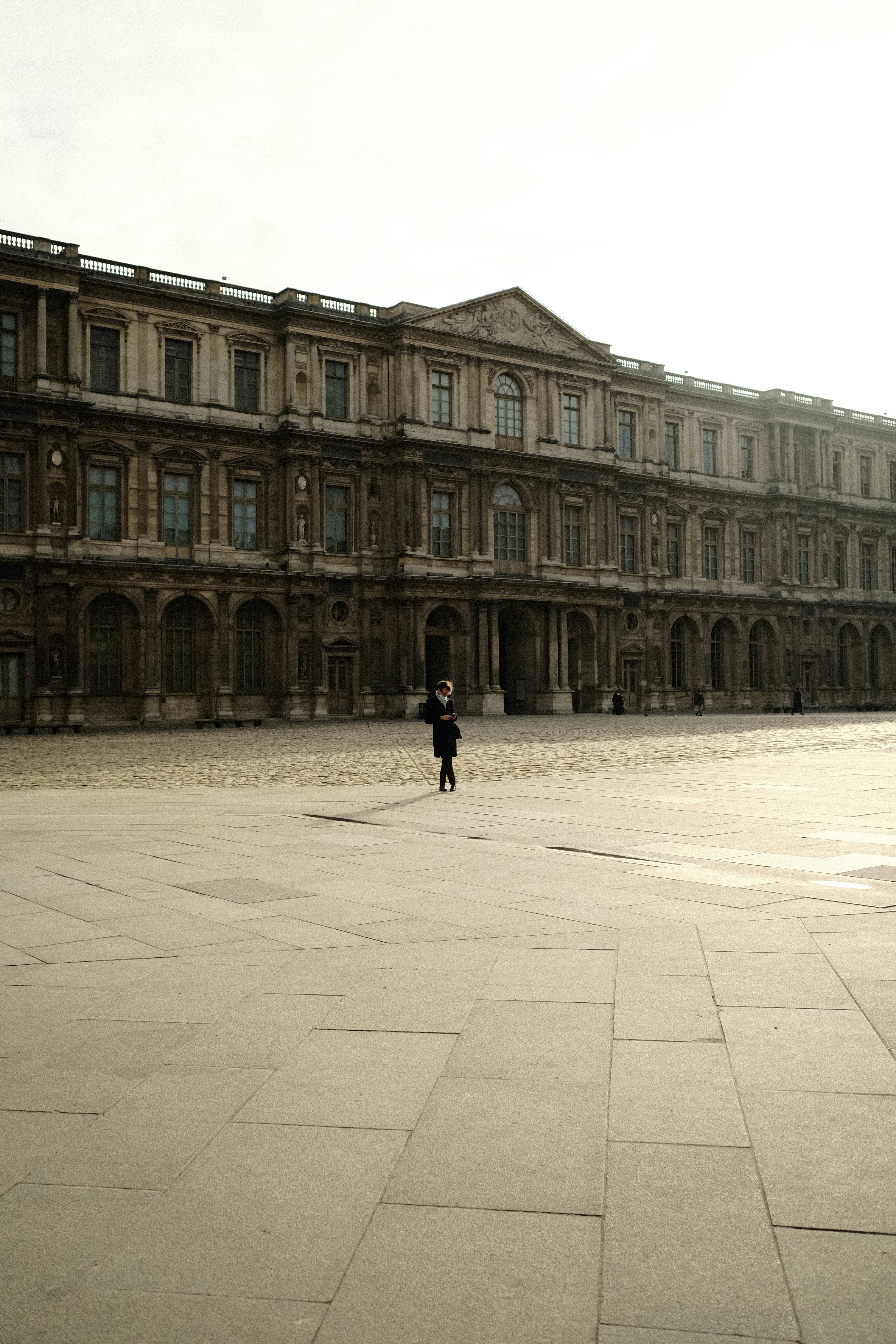 Une personne debout devant un grand bâtiment photo – Photo Photographie ...