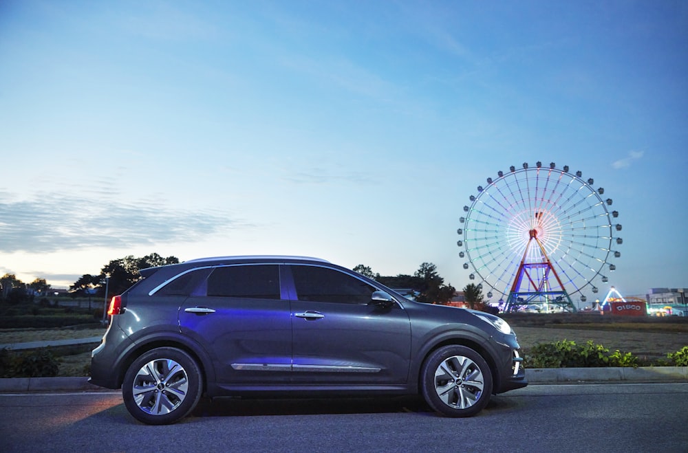 a car parked in front of a ferris wheel