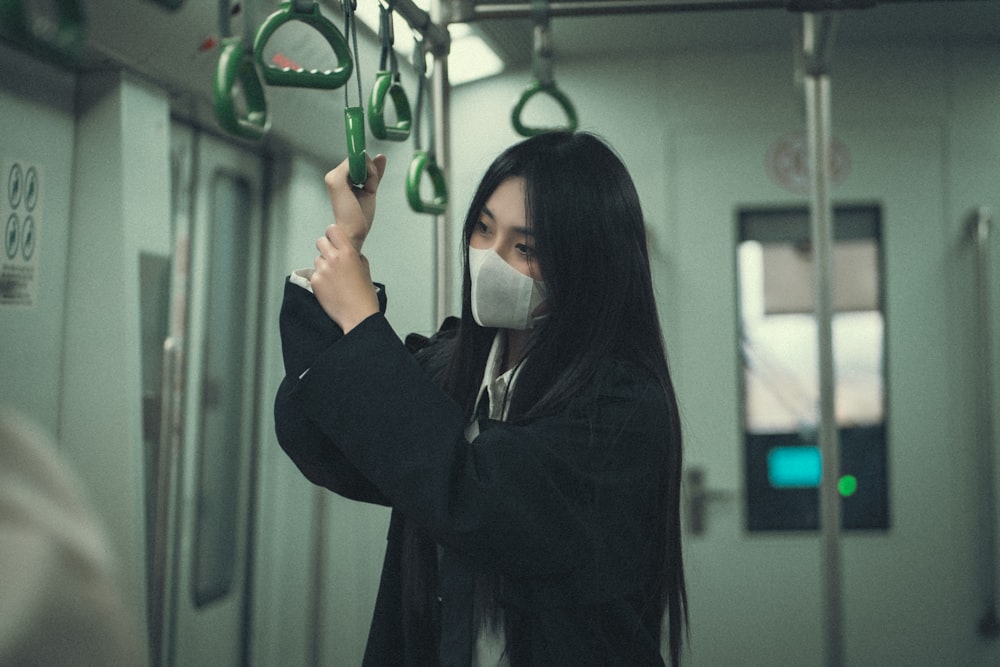 a woman wearing a face mask on a train