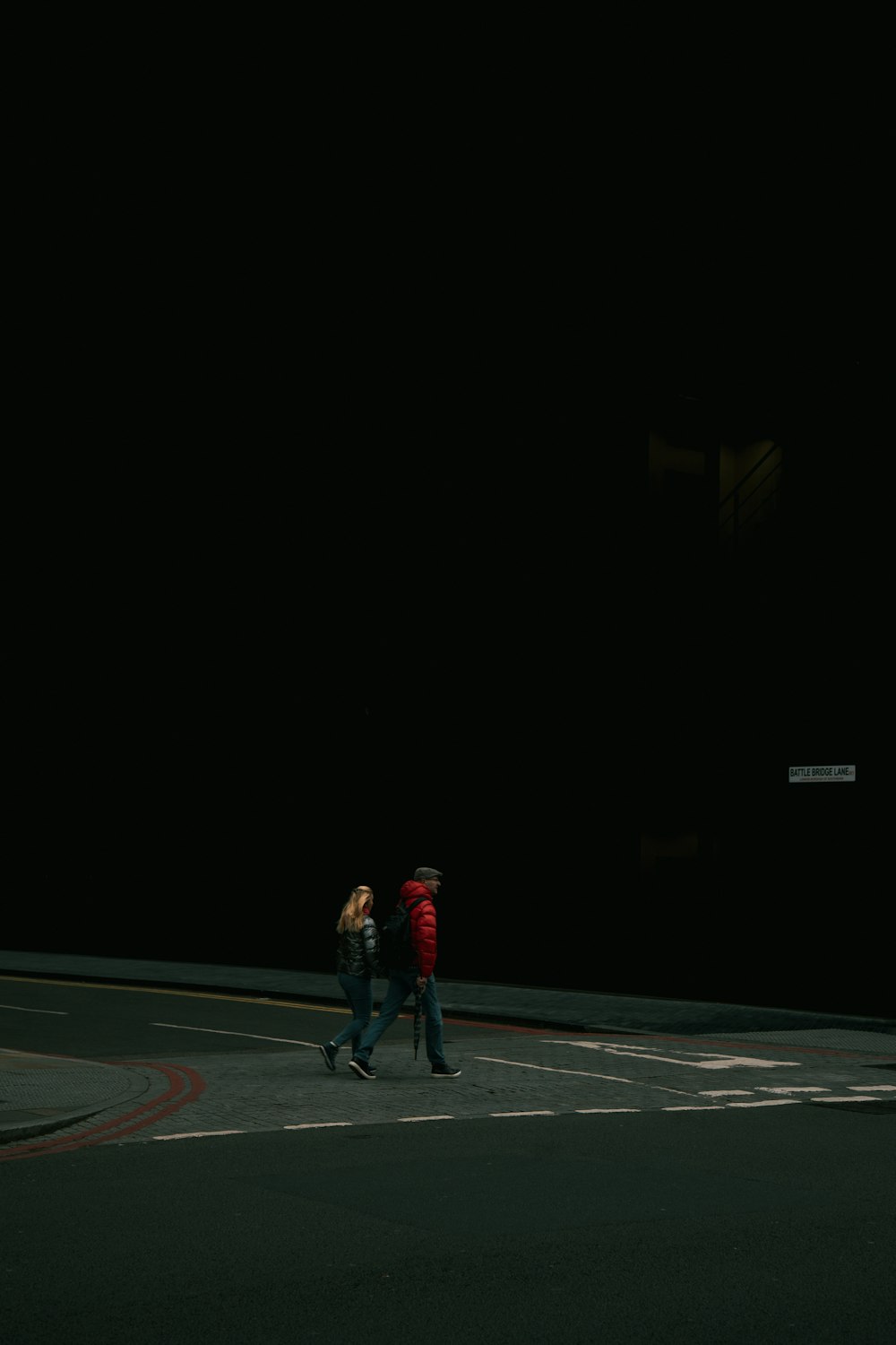 two people walking down a street at night