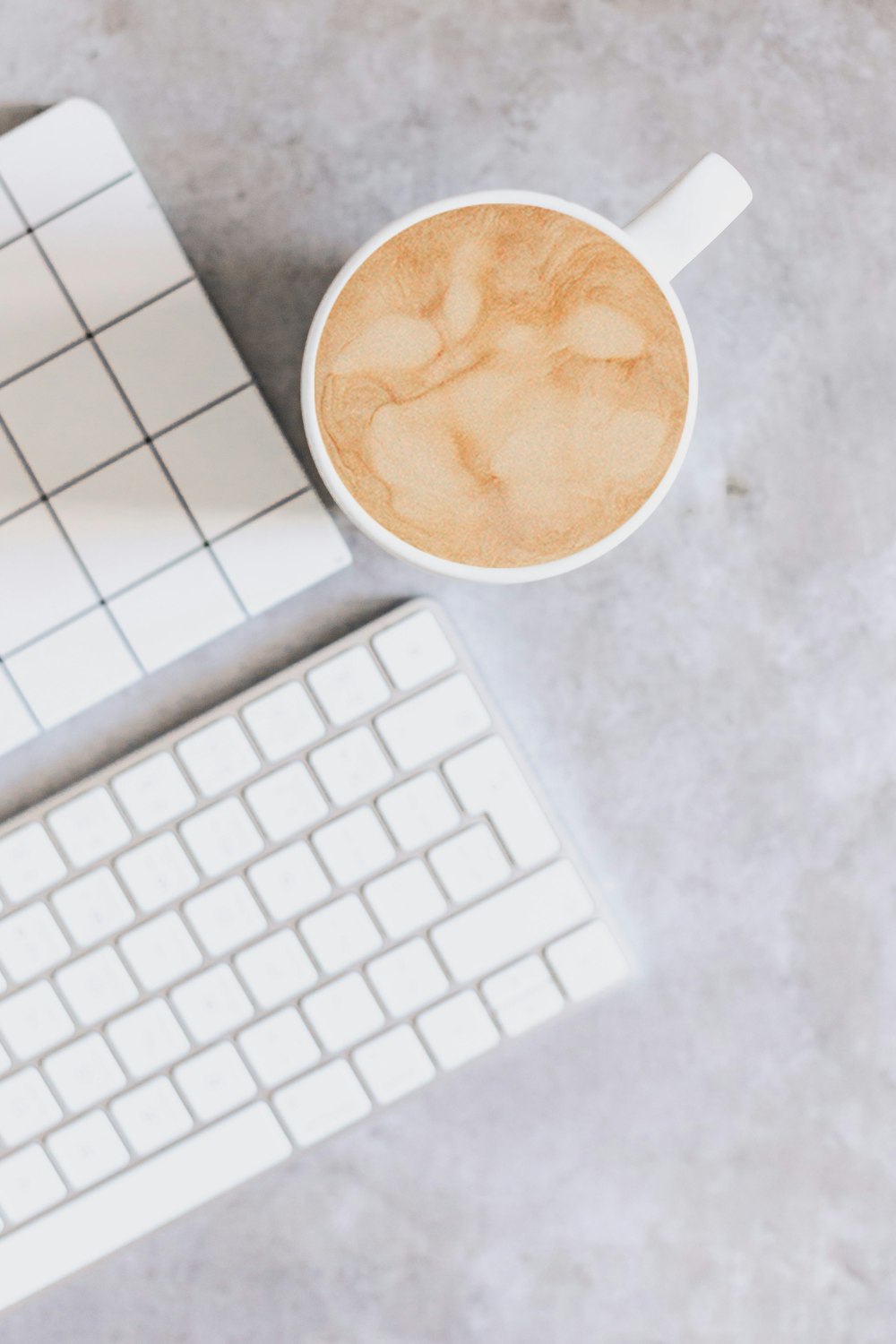 a cup of coffee sitting next to a keyboard