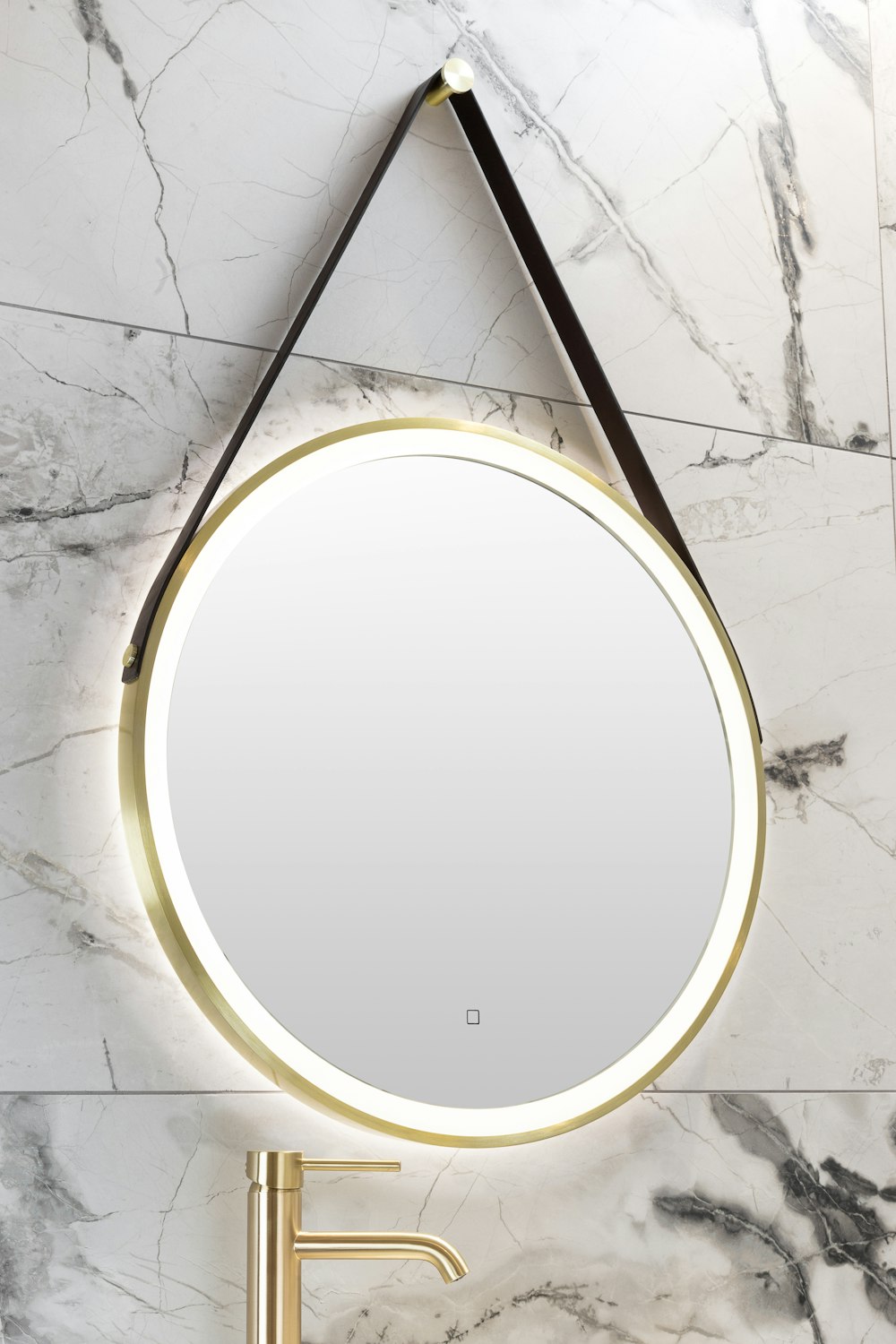 a round mirror hanging on the wall above a sink